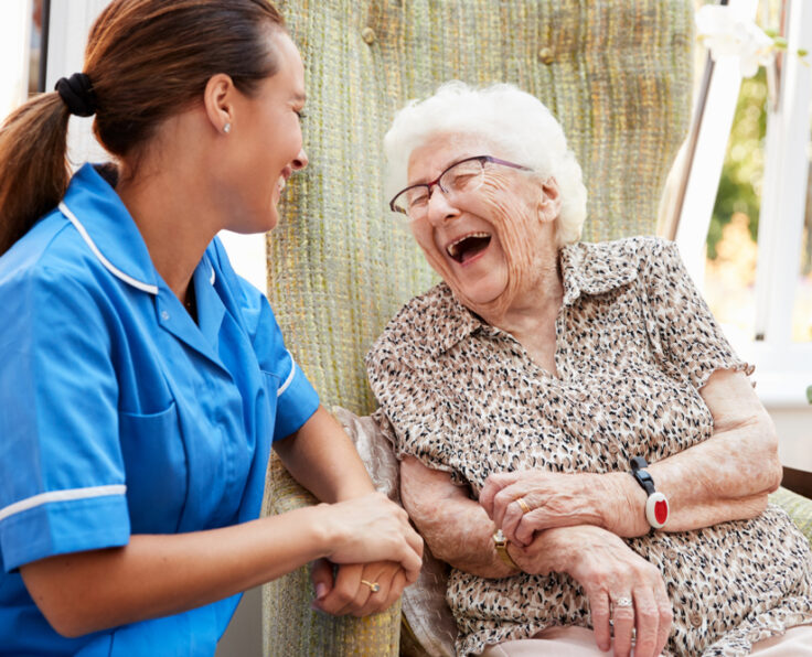 Senior,Woman,Sitting,In,Chair,And,Talking,With,Nurse,In